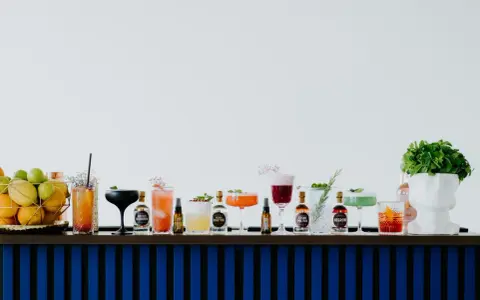 Kolorowe drinki z adwokatem i buteleczki z alkoholami na barze.