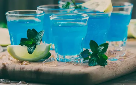 Orzeźwiający blue curacao drink z miętą i limonką, podany na lodzie. Idealny na letnie wieczory.