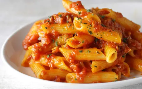 Penne Arrabbiata przepis na pikantny makaron z sosem pomidorowym i czosnkiem, posypany natką pietruszki.