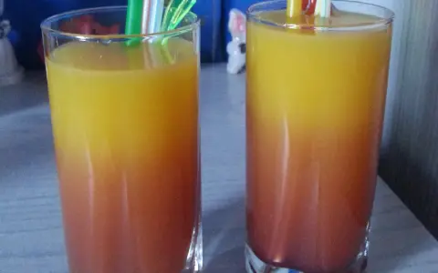 Dwa orzeźwiające drinki z sokiem malinowym, tworzące piękny gradient od czerwieni do żółci, gotowe do degustacji.