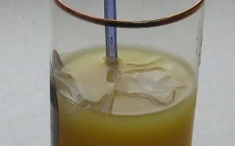Orzeźwiający gin z sokiem pomarańczowym, z kostkami lodu i niebieską słomką.