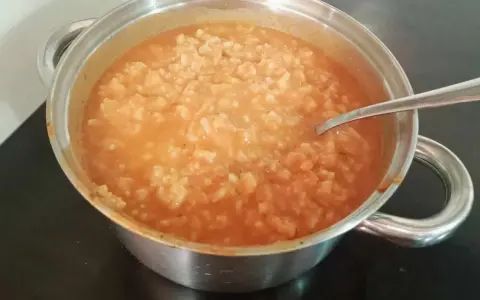 Gęsta zupa pomidorowa z ryżem w garnku, gotowa do podania. Idealny przepis na szybki obiad.