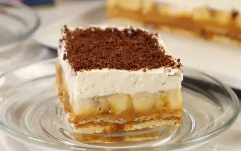 Pyszny kawałek Banoffee Pie z bananami, karmelem i bitą śmietaną, posypany czekoladą. Idealny przepis na deser.