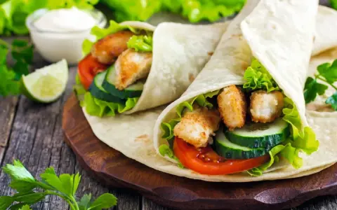 Tortilla z kurczakiem, pełna świeżych warzyw i chrupiącego kurczaka, wygląda pysznie. Lepsza niż domowa pizza!