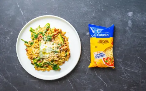 Pyszny makaron orzo z warzywami i serem, obok paczka jajecznej "ryżowej" Lubelli.