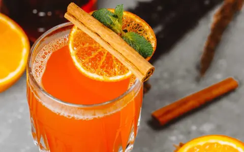 Orzeźwiający aperol z wódką, ozdobiony plasterkiem pomarańczy, listkami mięty i laską cynamonu. Idealny na letnie wieczory.