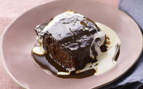 Pyszny Sticky Toffee Pudding przepis. Wilgotne ciasto oblane gorącym sosem toffi i śmietanką.