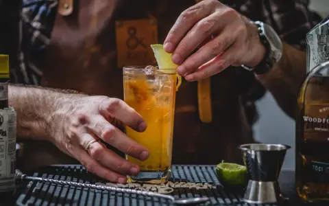 Barman kończy przygotowywać drinka na tequili, dodając plasterek limonki.