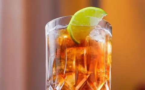 Orzeźwiający Long Island drink z lodem i plasterkiem limonki, idealny na letnie wieczory.