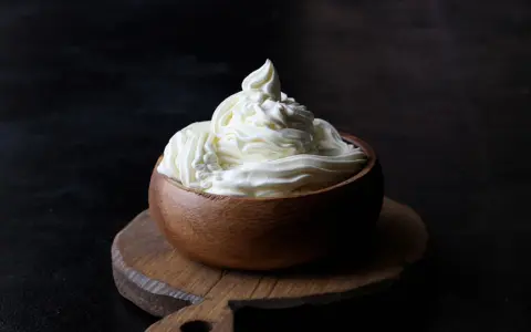 Kremowa masa w drewnianej miseczce, idealna do deserów. Mascarpone kontra serek homogenizowany – który wybierzesz?