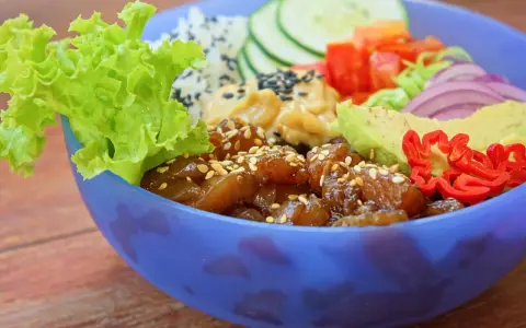 Kolorowy Poke Bowl przepis: ryż, sałata, awokado, ogórek, pomidor, cebula i pikantna papryczka.