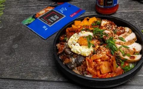 Pyszny Bibimbap przepis z kurczakiem, jajkiem sadzonym, grzybami, marchewką i kimchi. Idealny na szybki obiad.
