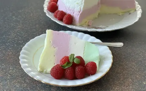 Puszysta pianka z galaretki i jogurtu w kolorach pastelowych, udekorowana malinami.