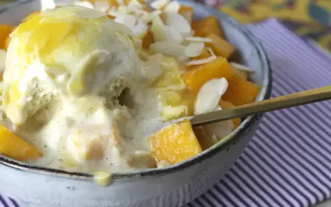 Pyszny deser Bingsu przepis: lody waniliowe z mango, płatkami migdałów i syropem.