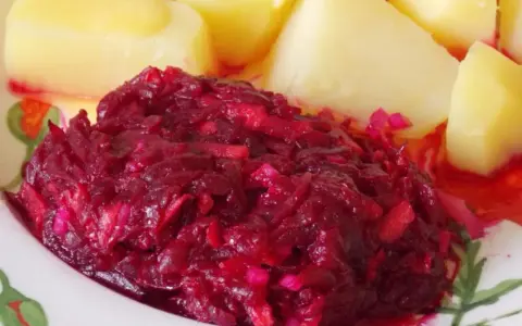 Buraczki zasmażane obok ziemniaków, a obok nich surówka z marchewki i jabłka.