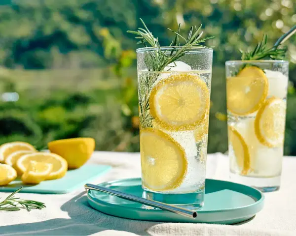 Orzeźwiający drink bezalkoholowy mocktail z cytryną i rozmarynem, obok klasycznego koktajlu. Idealny na upalne dni.