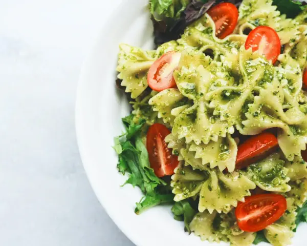 Makaron farfalle z pesto, pomidorkami koktajlowymi i sałatą. Idealny pomysł, co jeść na obiad żeby schudnąć.