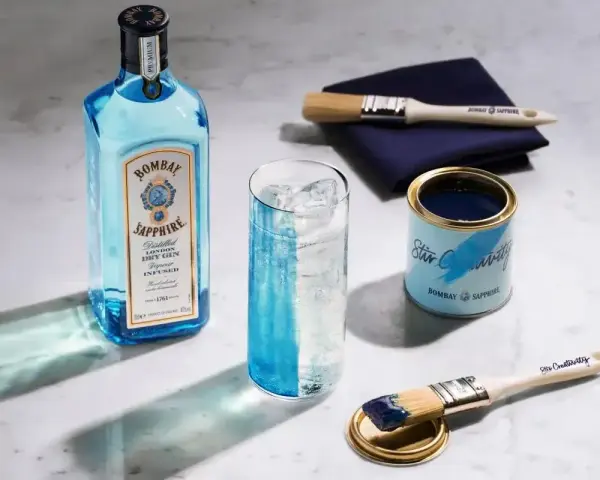 Butelka Bombay Sapphire, szklanka z lodem i drinkiem, puszka z farbą i pędzle. Jak pić blue gin? Stwórz własny drink!