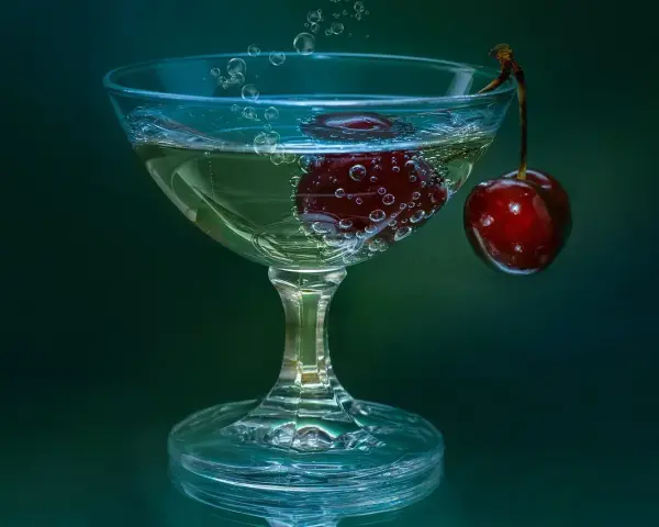 Gin lubelski czy Seagram’s do domowych drinków? W kieliszku bąbelki unoszą się wokół wiśni, tworząc orzeźwiającą kompozycję.