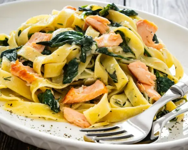 Makaron tagliatelle z łososiem i szpinakiem. Pyszny pomysł na obiad, który zadowoli każdego smakosza.