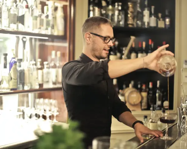 Barman po kursie przygotowuje drinka. Zastanawiasz się, ile zarabia barman po kursie?