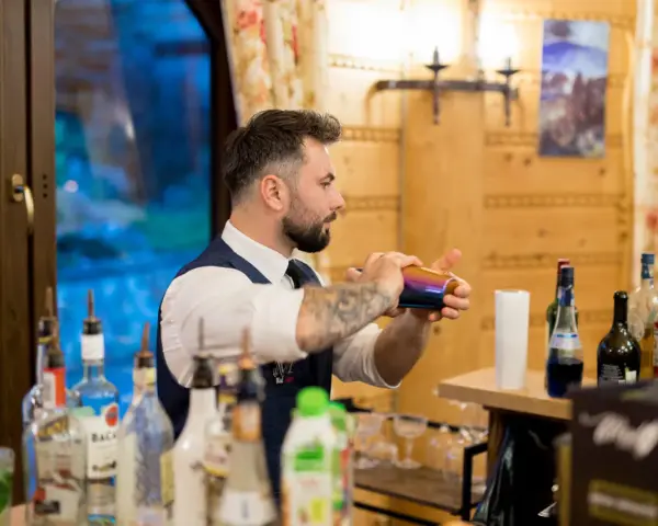 Barman przygotowuje drinki na wesele. Sprawdź nasz drink bar na wesele cennik i zamów najlepsze koktajle!