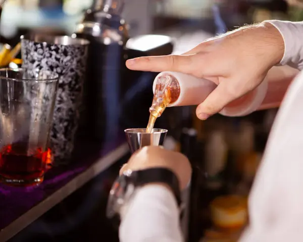 Barman w Toruniu precyzyjnie nalewa alkohol. Zastanawiasz się, ile zarabia barman w Toruniu?