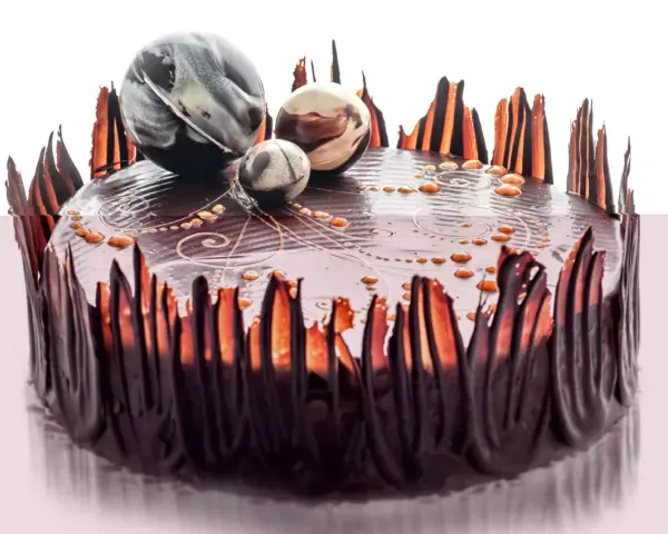 Elegancki tort czekoladowy ozdobiony czekoladowymi piórami i marmurkowymi kulami. Inspiracja, jak ozdobić tort czekoladowy.