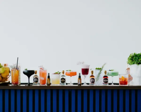 Kolorowe drinki z adwokatem i buteleczki z alkoholami na barze.
