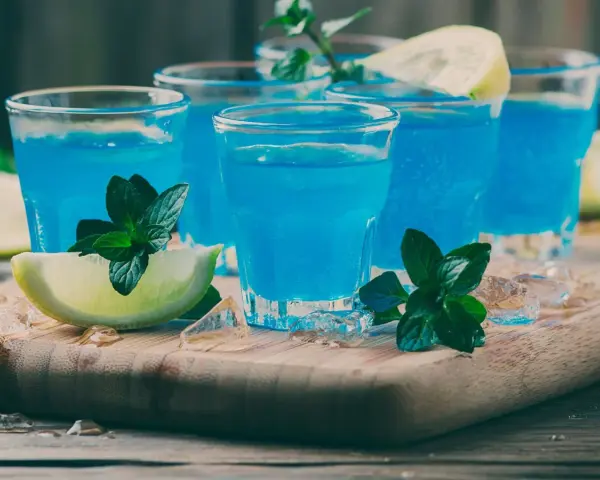 Orzeźwiający blue curacao drink z miętą i limonką, podany na lodzie. Idealny na letnie wieczory.
