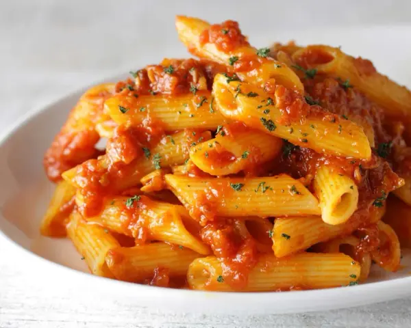 Penne Arrabbiata przepis na pikantny makaron z sosem pomidorowym i czosnkiem, posypany natką pietruszki.
