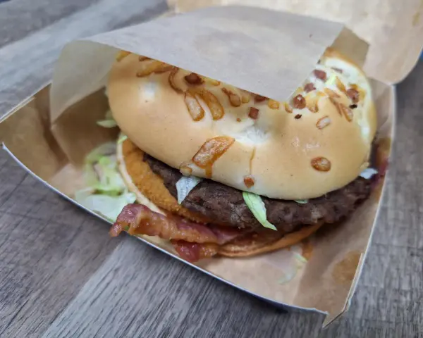 Burger domowy kontra cheeseburger z sieciówki. Ten domowy burger z bekonem i serem na bułce wygląda apetycznie.