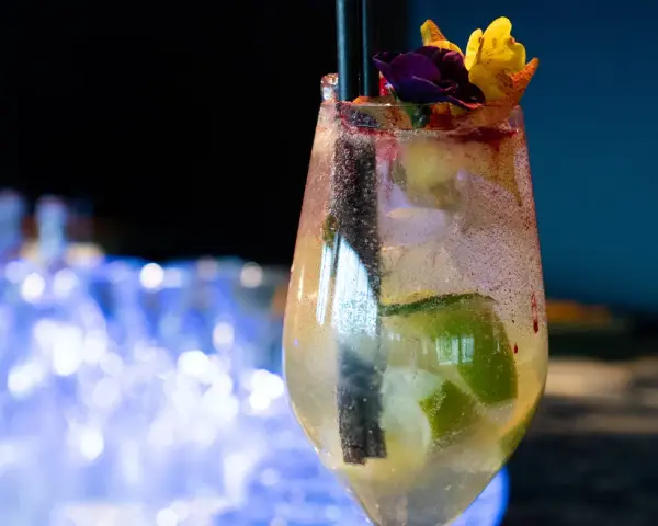 Orzeźwiający drink prosecco sprite z limonką i kwiatową dekoracją, idealny na letnie wieczory.