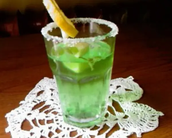 Orzeźwiający drink z likierem miętowym, lodem i plasterkiem cytryny, ozdobiony cukrowym rantem.