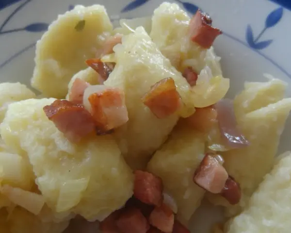 Kopytka z sosem i skwarkami z boczku, pyszne danie.