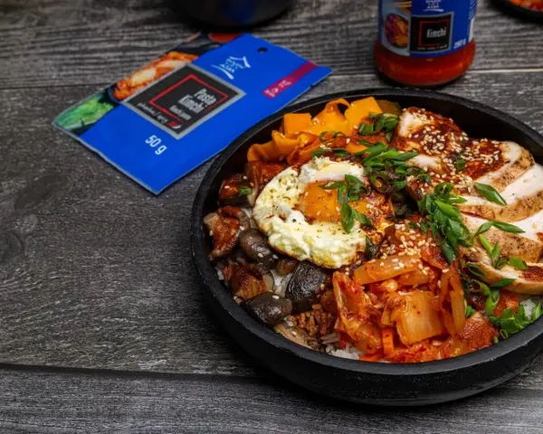 Pyszny Bibimbap przepis z kurczakiem, jajkiem sadzonym, grzybami, marchewką i kimchi. Idealny na szybki obiad.