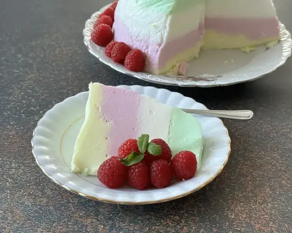 Puszysta pianka z galaretki i jogurtu w kolorach pastelowych, udekorowana malinami.