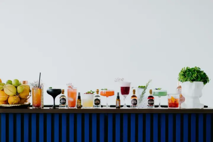 Kolorowe drinki z adwokatem i buteleczki z alkoholami na barze.