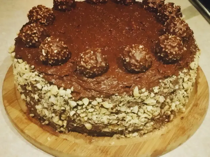 Czekoladowy tort udekorowany chrupiącymi orzechami i pysznymi pralinami Ferrero Rocher.
