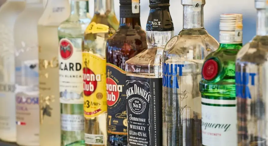 Szereg butelek alkoholi: wódka, rum, whisky, gin. Idealne do shotów warstwowych kontra shoty mieszane.