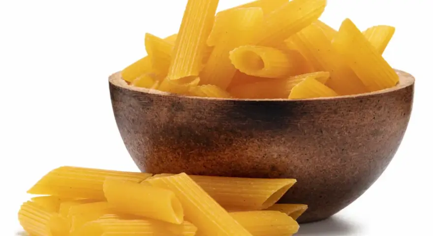 Makaron bezglutenowy kukurydziany w drewnianej misce, obok garść makaronu. Ryżowy też jest pyszny!