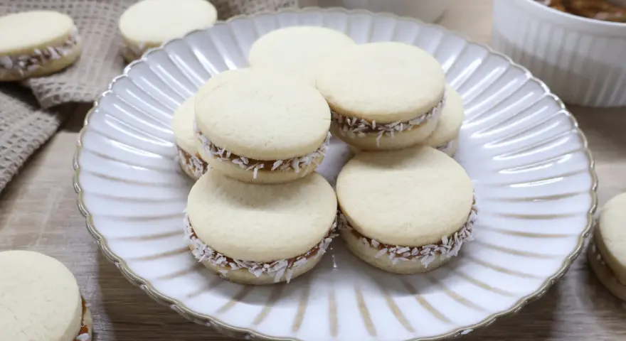 Pyszne domowe alfajores z kajmakiem i wiórkami kokosowymi. Idealne na deser, zgodnie z przepisem na alfajores.