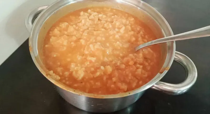 Gęsta zupa pomidorowa z ryżem w garnku, gotowa do podania. Idealny przepis na szybki obiad.