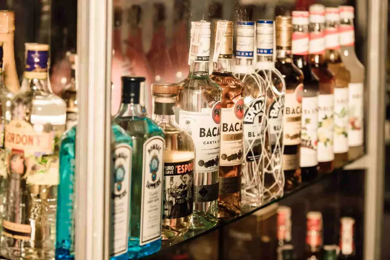 Rzędy butelek alkoholu, w tym Bacardi i Gordon's. Zastanawiasz się, ile bierze barman na weselu? To zależy od wielu czynników, ale na pewno potrzebuje dobrego zaplecza!