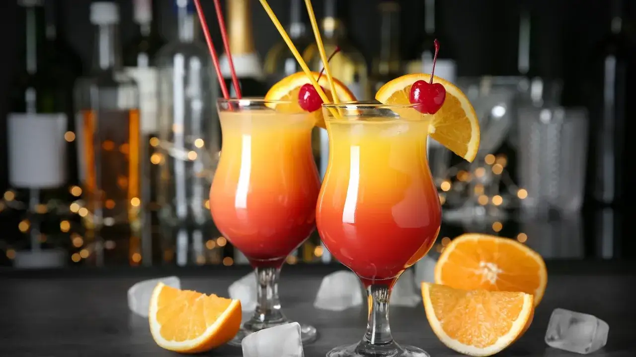 Dwa drinki z pomarańczą i wiśnią, idealne, by dowiedzieć się, jak zrobić drinka.