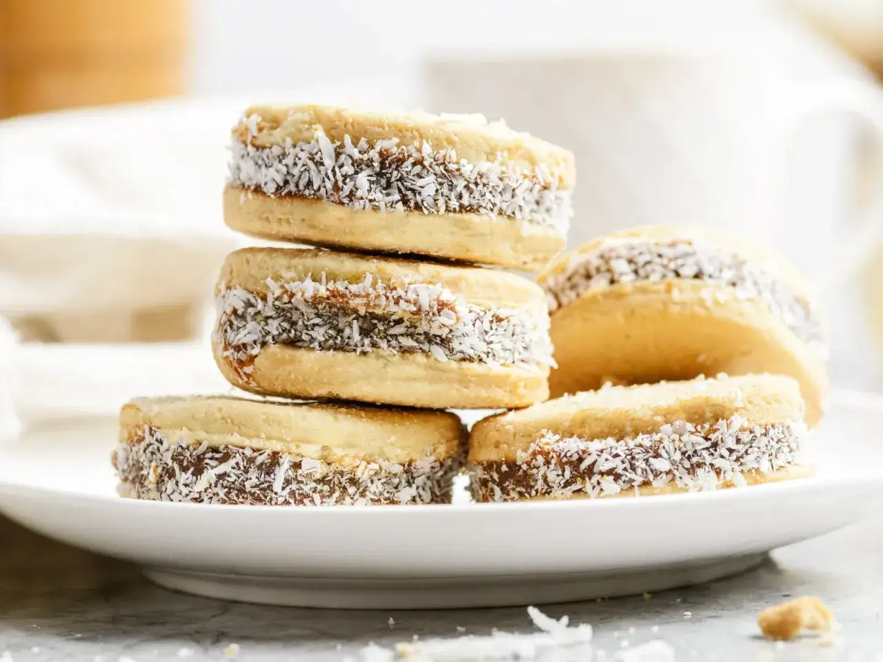 Pyszne domowe alfajores z kajmakiem i wiórkami kokosowymi. Idealne do kawy, gdy masz ochotę na coś słodkiego. Alfajores przepis w zasięgu ręki!