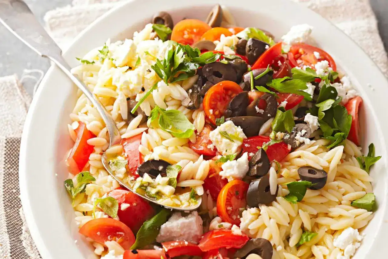 Pyszna sałatka z makaronem orzo, pomidorami, oliwkami i fetą. Wygląda jak ryż, ale to pyszny makaron!