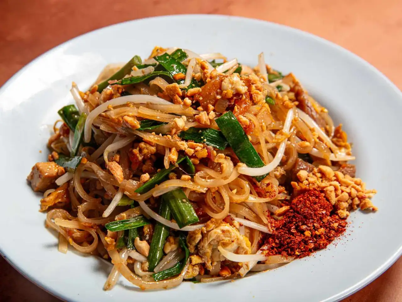 Pad Thai z makaronem ryżowym szerokim, kiełkami, orzeszkami i chili. Wybór między szerokim makaronem ryżowym a nitkami jest trudny!