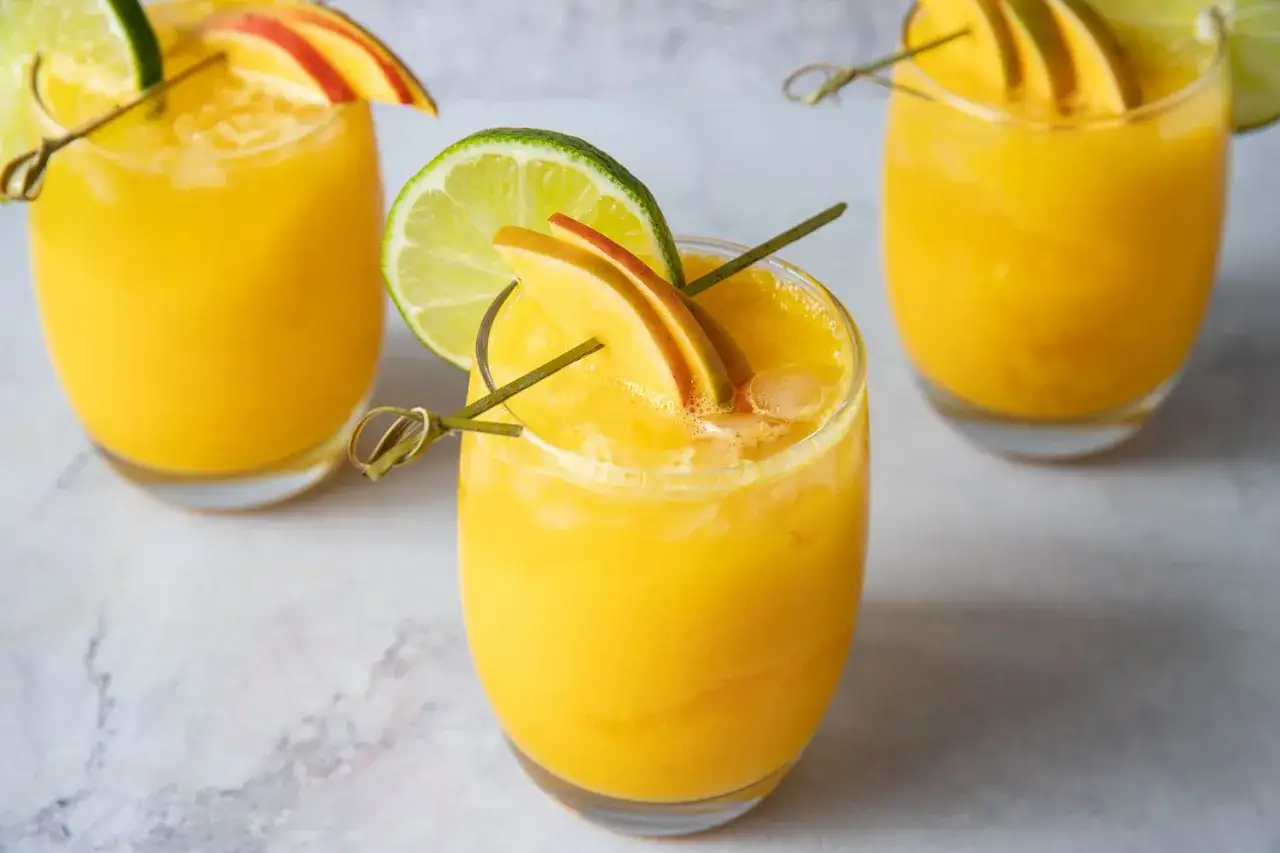 Orzeźwiający drink z marakują kontra drink z mango. Oba podane z plasterkiem limonki i owoców.
