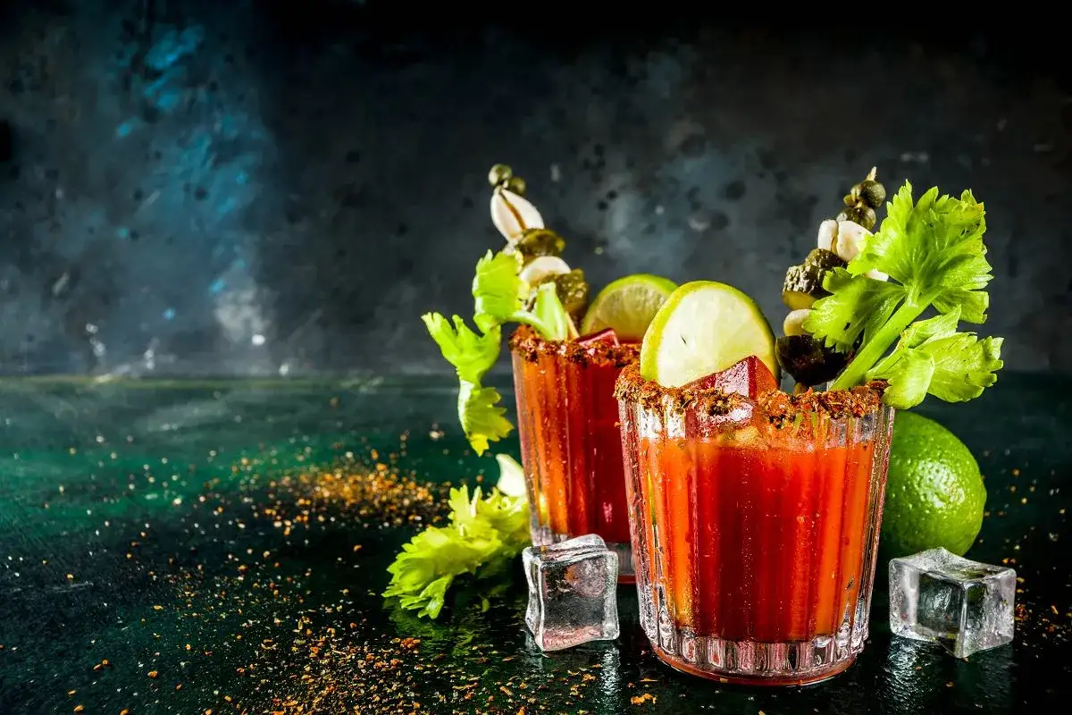 Dwa drinki Krwawa Mary, idealne na brunch w lokalach, gdzie barmani polecają je z dodatkami: selerem, limonką i piklami.